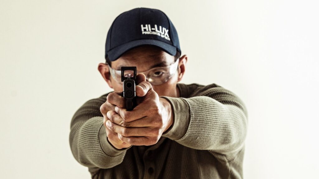 Man holding pistol out in front. Photo by Hi-Lux