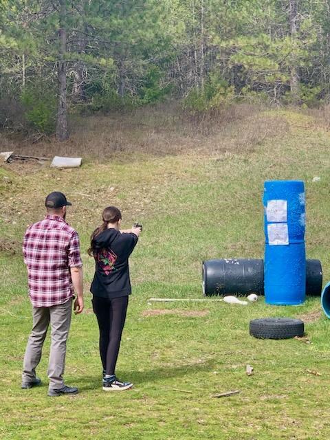 man and girl shooting at range