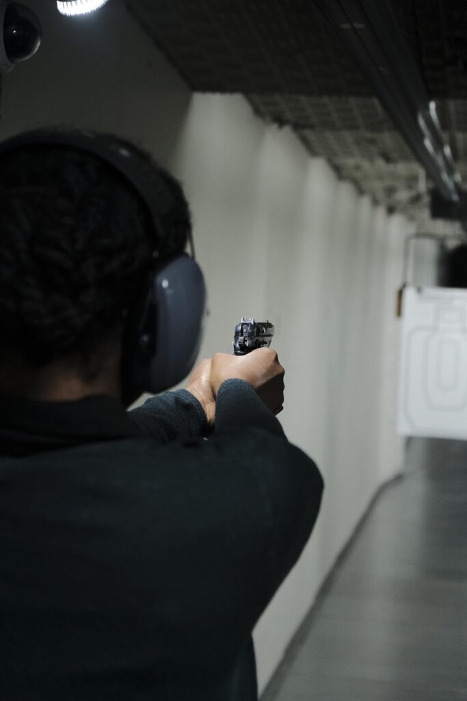 darkened photo of man indoors shooting pistol