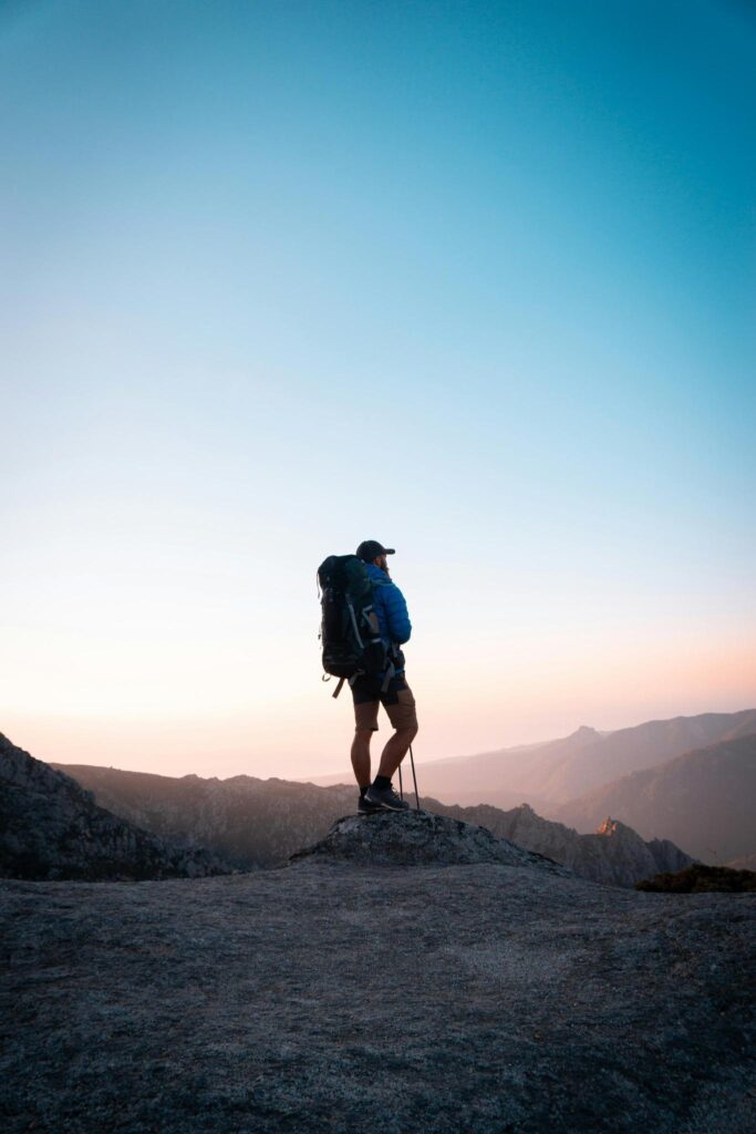 silhouette of man hiking on hill