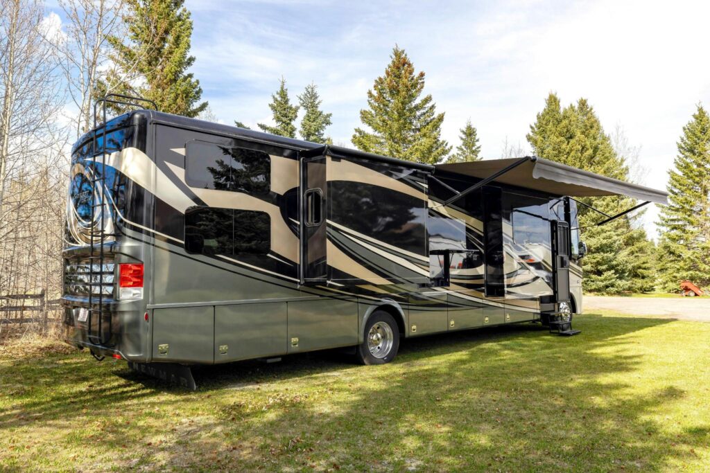 large rv in a field with awning