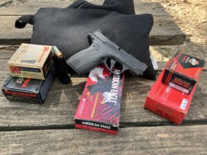 pistol with ammunition boxes on shooting bench