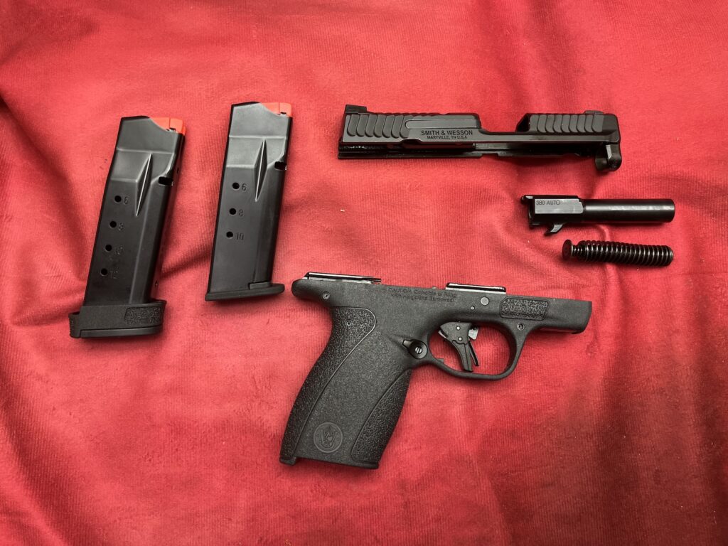disassembled pistol on red backdrop