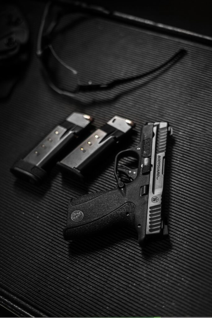 pistol with. magazines on black backdrop