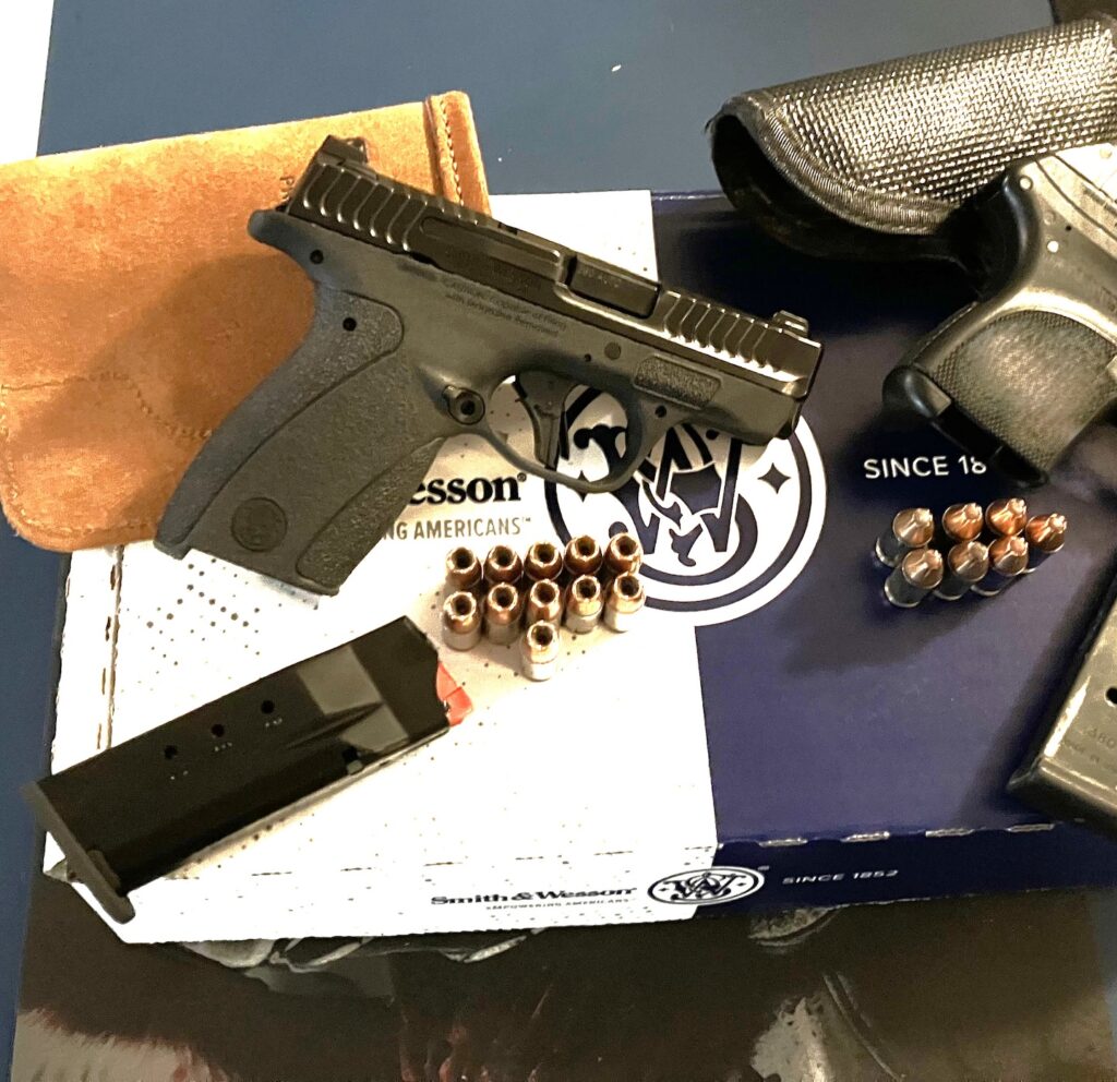 pistol resting on box with ammo and magazines