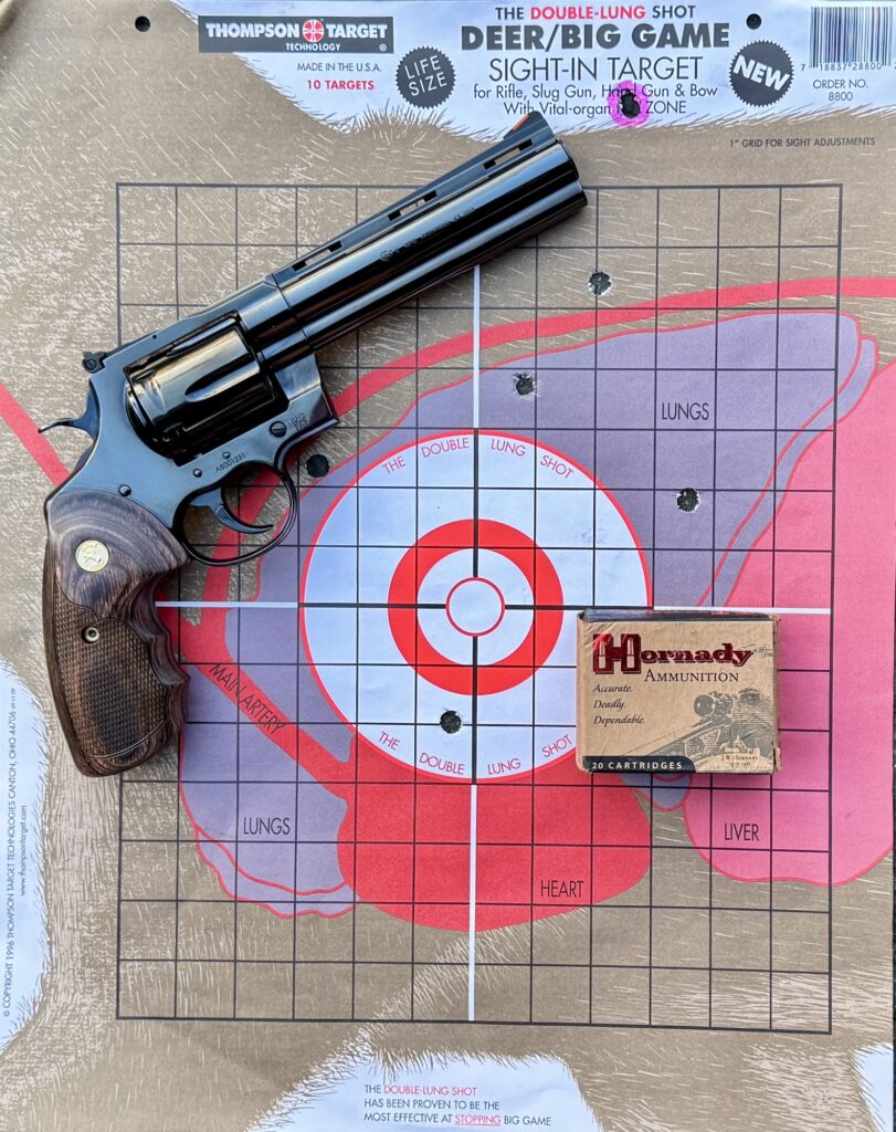 Revolver on used target with box of ammunition
